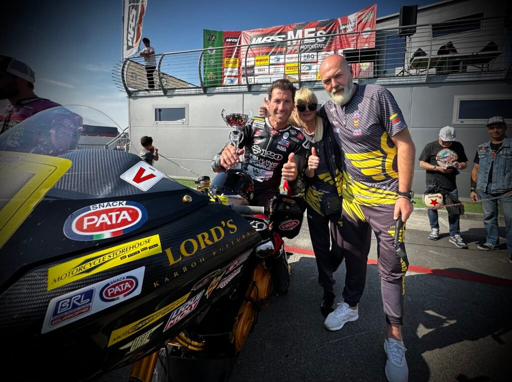 Ruben Xaus holding a trophy with Loreta and Dainius Suckeliai beside LORD’S BEE #88 at the BRL European Cup Cremona round.